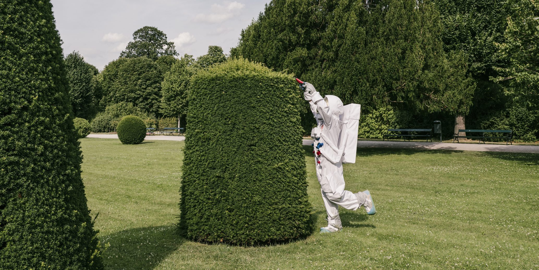 Astronaut schneidet Hecke