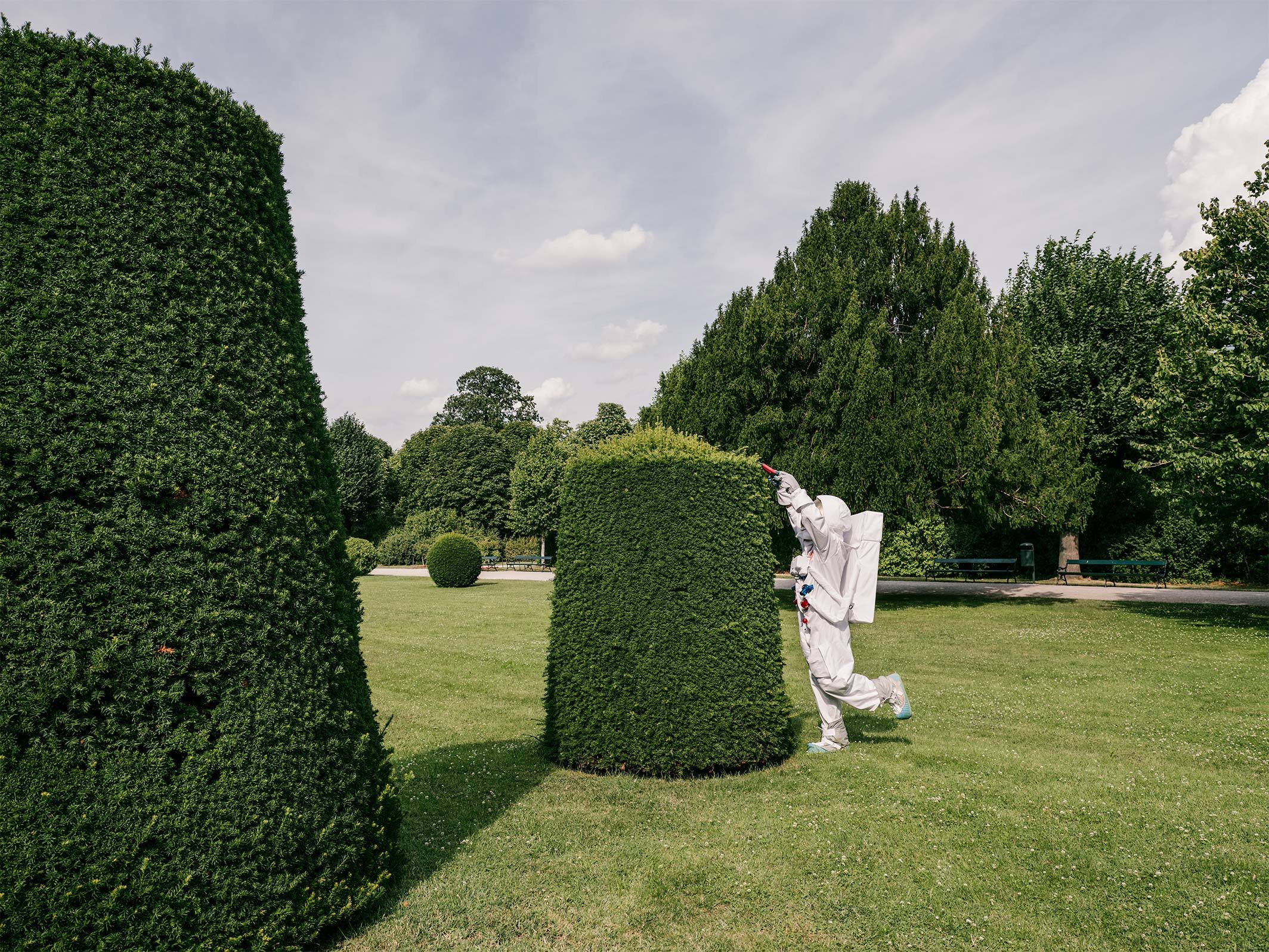 Astronaut schneidet Hecke